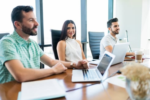 people sitting at a conference table with laptops