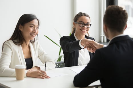businessman-shaking-hand-female-coworker-during-company-meeting