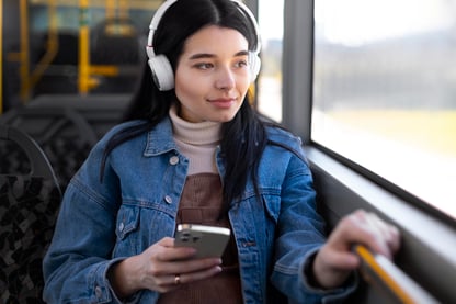 women wearing headphones on public transportation